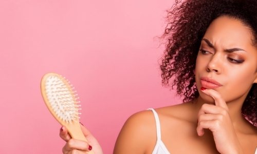 woman looking at hairbrush