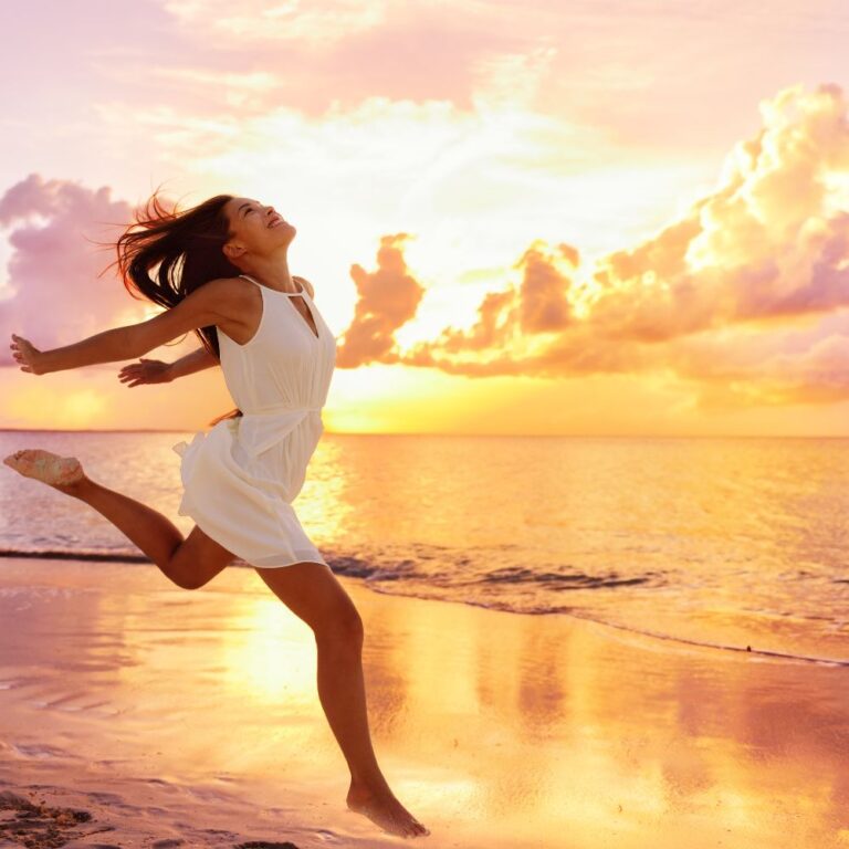 woman running on the beach with a sunset